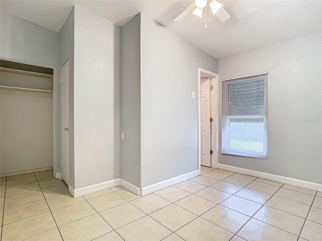 unfurnished bedroom featuring light tile patterned floors, ceiling fan, and a closet