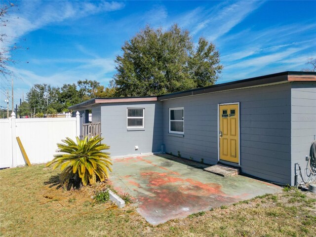 back of property with a patio and a lawn