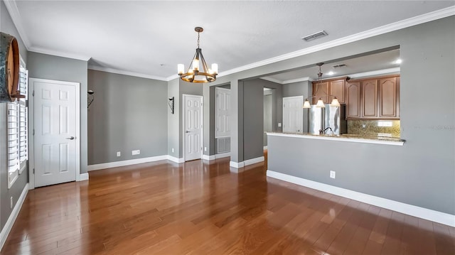 interior space featuring a notable chandelier, crown molding, and dark wood-type flooring