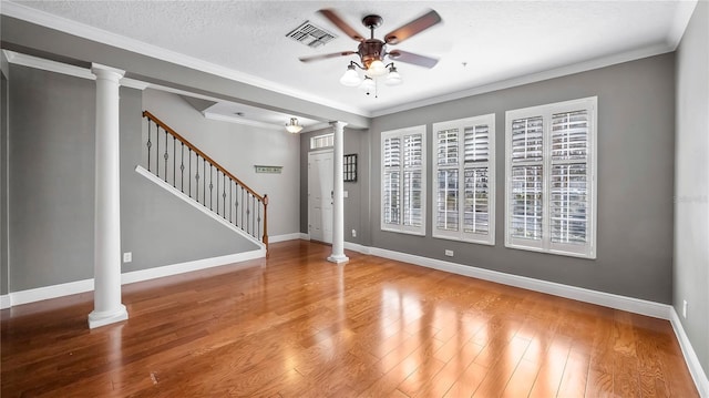 unfurnished living room featuring ornate columns, hardwood / wood-style floors, and ceiling fan