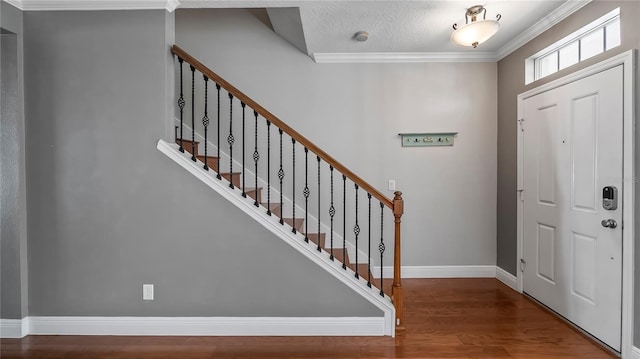 foyer featuring crown molding, hardwood / wood-style floors, and a textured ceiling