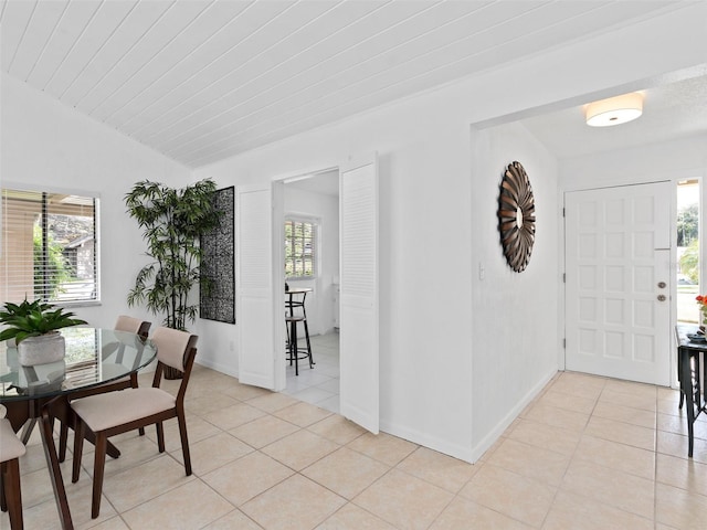 dining room with light tile patterned floors and vaulted ceiling