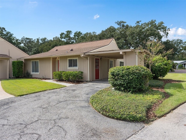 ranch-style home with a carport and a front lawn