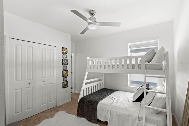 carpeted bedroom featuring ceiling fan and a closet