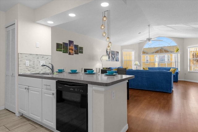 kitchen with lofted ceiling, white cabinets, wood-type flooring, and dishwasher