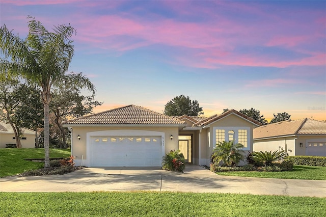 view of front of property with a garage and a lawn