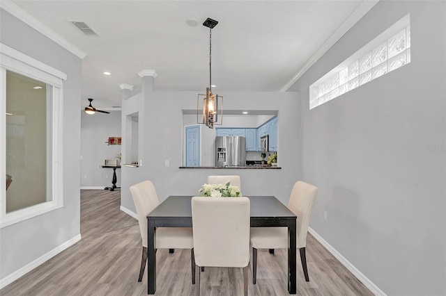 dining room with crown molding and light hardwood / wood-style flooring