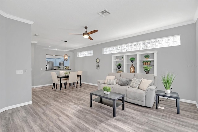 living room featuring crown molding, ceiling fan, and light hardwood / wood-style floors