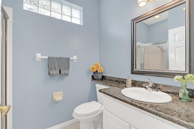 bathroom featuring a shower with door, vanity, and toilet