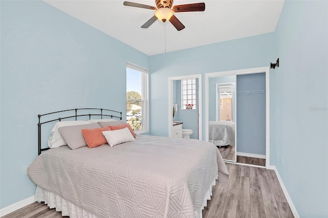 bedroom with hardwood / wood-style flooring, connected bathroom, and ceiling fan