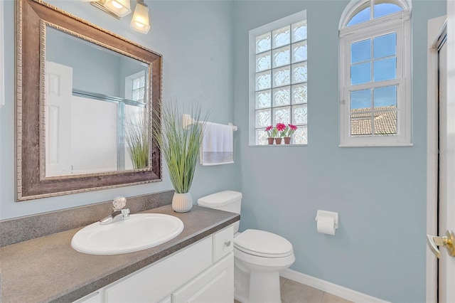 bathroom featuring vanity, tile patterned flooring, toilet, and walk in shower