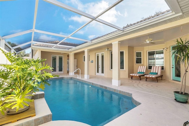 view of swimming pool with a patio, glass enclosure, ceiling fan, and french doors