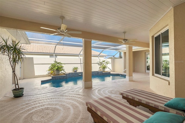 view of swimming pool with ceiling fan, glass enclosure, and a patio area