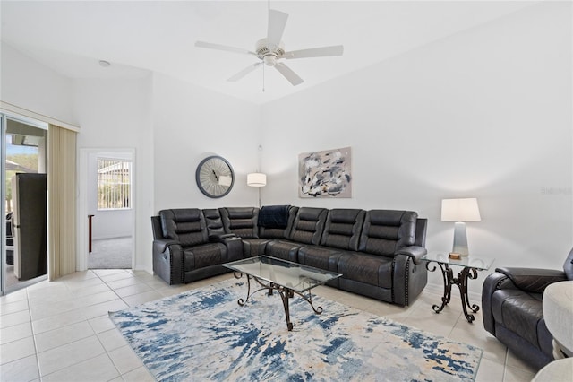 living room with ceiling fan, a high ceiling, and light tile patterned floors