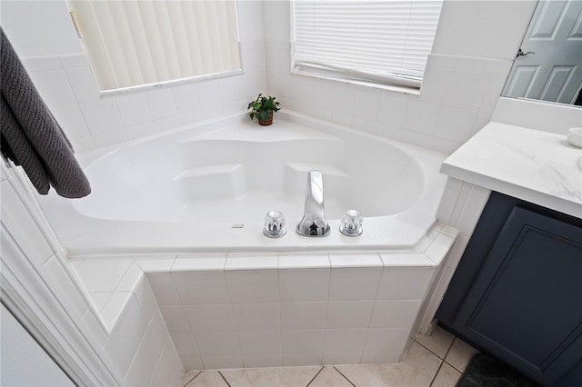 bathroom with vanity, tile patterned flooring, and tiled tub