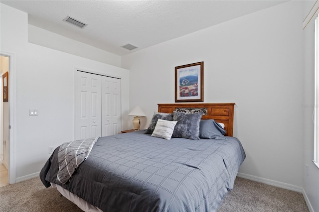 carpeted bedroom featuring a closet and a textured ceiling