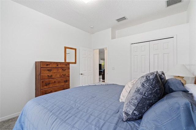 bedroom featuring a closet, a textured ceiling, and carpet