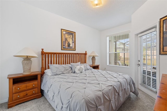 carpeted bedroom featuring access to outside and a textured ceiling