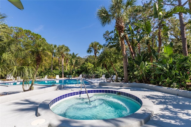 community pool featuring a community hot tub and a patio area