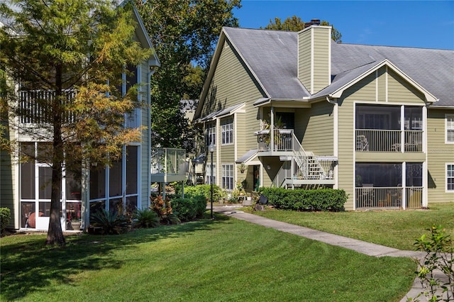 view of front facade with a chimney and a front lawn