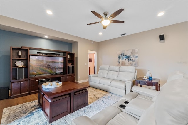 living room featuring ceiling fan and light hardwood / wood-style flooring