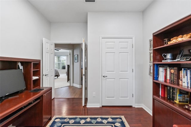 home office with dark wood-type flooring