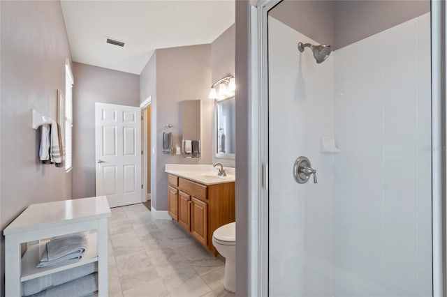 bathroom with vanity, toilet, and a tile shower