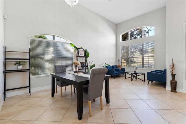 tiled dining room with an inviting chandelier and high vaulted ceiling