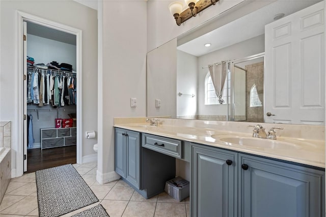 bathroom with tile patterned flooring, vanity, toilet, and a shower with shower door