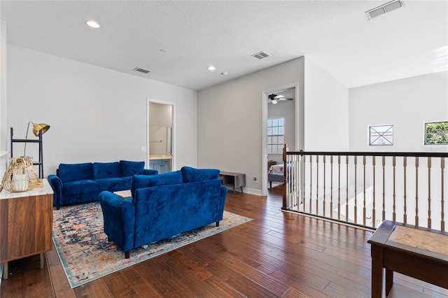 living room featuring dark wood-type flooring and a textured ceiling