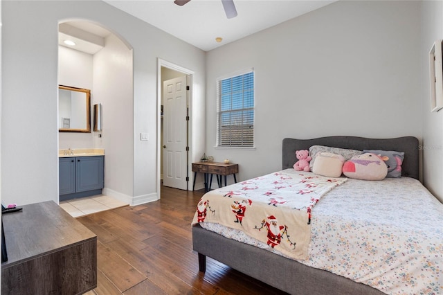 bedroom featuring ceiling fan, dark wood-type flooring, and ensuite bath