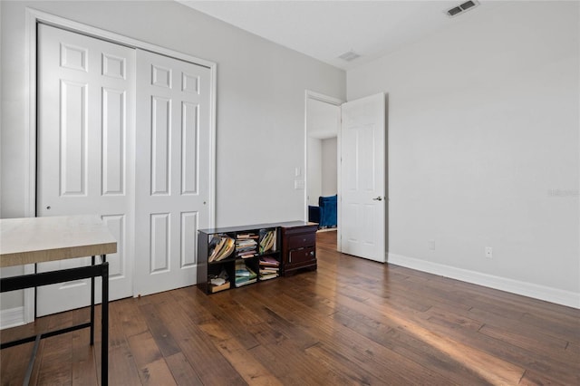 bedroom featuring dark wood-type flooring and a closet