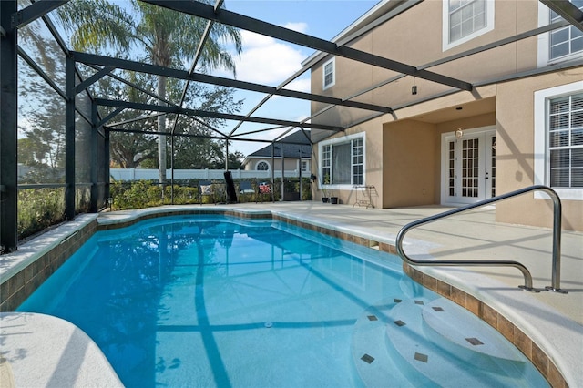 view of swimming pool featuring french doors, a lanai, and a patio