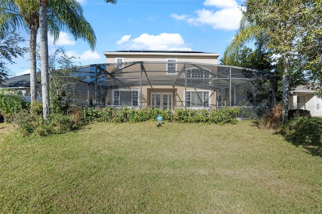 back of property featuring a yard and glass enclosure