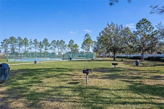 surrounding community featuring a lawn and tennis court