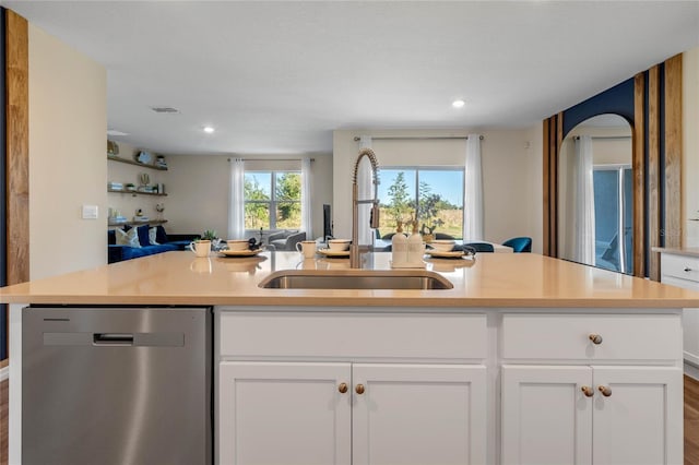 kitchen with sink, dark wood-type flooring, dishwasher, white cabinetry, and an island with sink