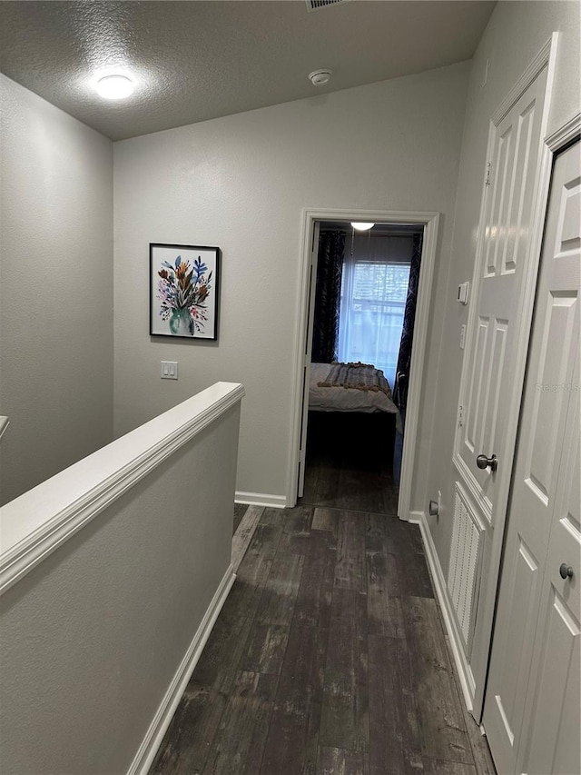 corridor featuring dark hardwood / wood-style floors and a textured ceiling