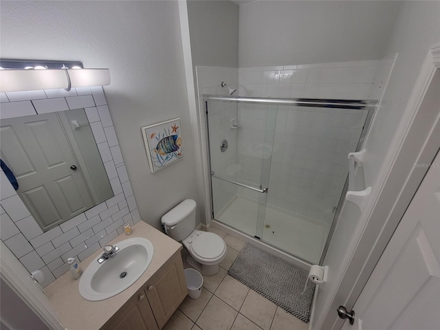 bathroom with vanity, a shower with shower door, tile patterned floors, and toilet