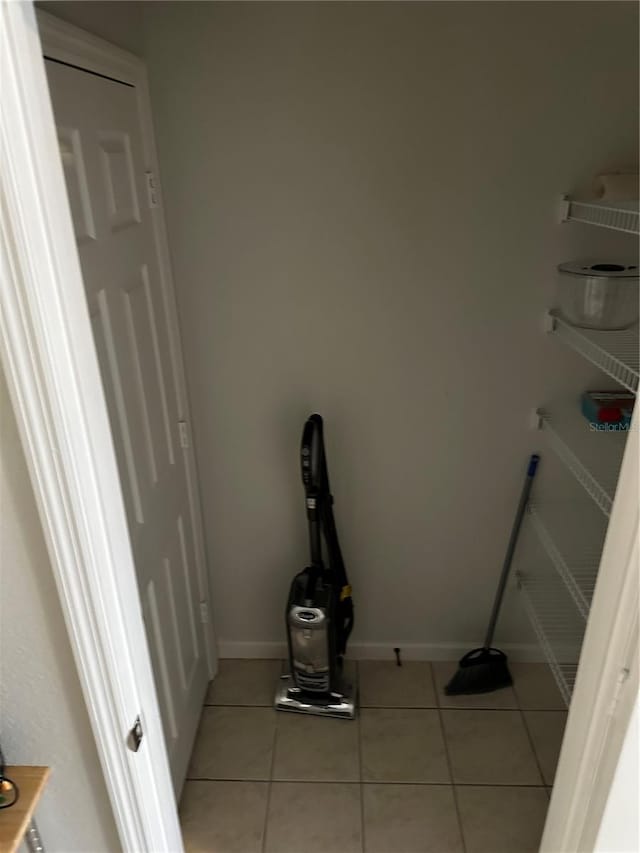 clothes washing area featuring light tile patterned floors