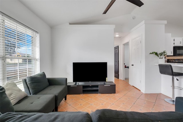 living room featuring vaulted ceiling, ceiling fan, and light tile patterned flooring