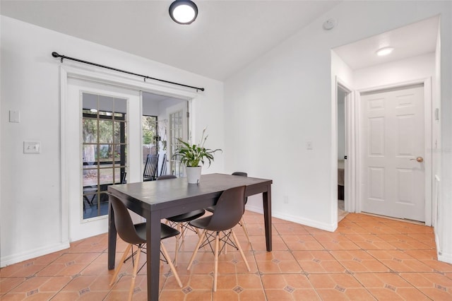 dining room with vaulted ceiling and light tile patterned floors