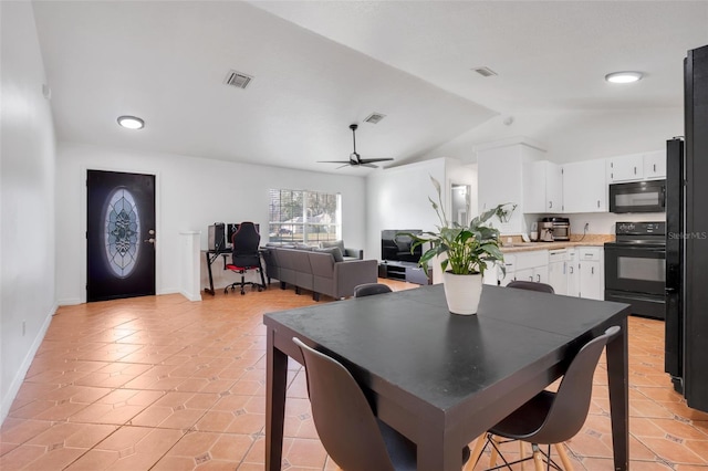 dining room featuring light tile patterned floors, vaulted ceiling, and ceiling fan