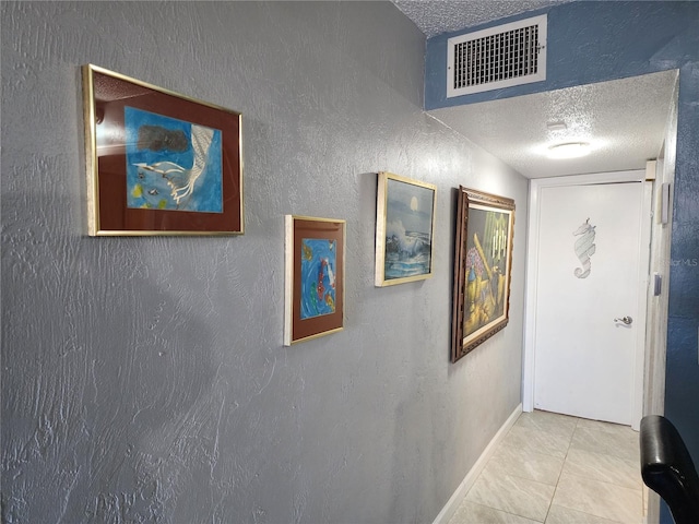 hallway with light tile patterned floors and a textured ceiling