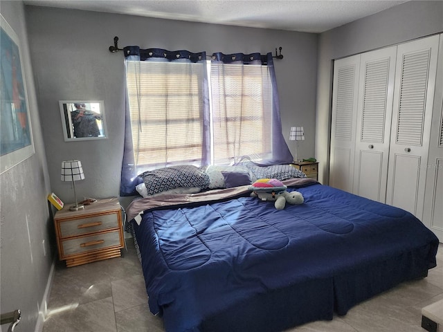 tiled bedroom with a closet and a textured ceiling