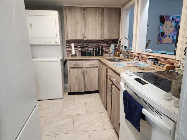 kitchen with light tile patterned flooring, sink, tasteful backsplash, white electric stove, and stacked washer / dryer