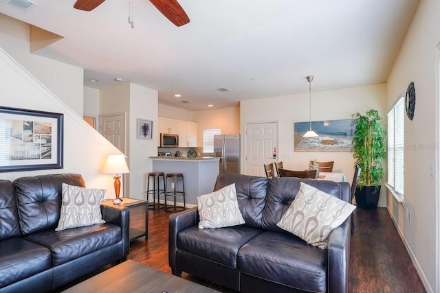 living room with ceiling fan and dark hardwood / wood-style floors