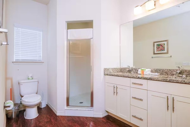 bathroom with hardwood / wood-style flooring, vanity, toilet, and an enclosed shower