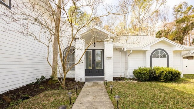 view of exterior entry with a yard