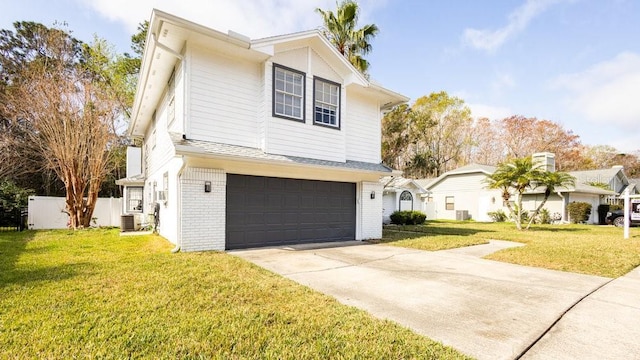 view of front of home with a garage, central AC, and a front yard