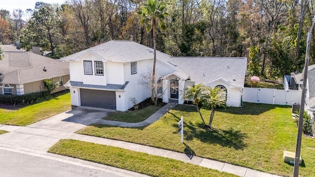 split level home featuring a garage and a front lawn